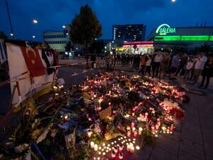 andles and flowers lie in front of the Olympia-Einkaufszentrum shopping centre on July 23, 2016 in Munich, southern Germany, one day after a teenage German-Iranian gunman killed nine people and wounded 16. (AFP/Sven Hoppe)