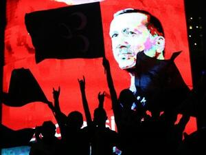 Supporters stands in front of a screen displaying a portrait of Turkish President Recep Tayyip Erdogan during a rally in Ankara on July 20, 2016. (AFP/File) 