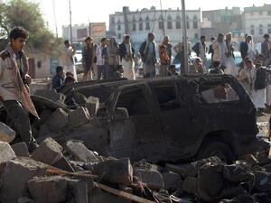 Yemenis stand at the site of a Saudi airstrike against Houthi rebels near Sanaa Airport last year, which killed at least 13 people. (AFP/Mohammed Huwais)