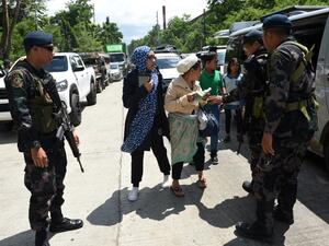 Philippine policemen check evacuees from Marawi aboard a van at a checkpoint by the entrance of Iligan City, in southern island of Mindanao on May 24, 2017. (AFP/Ted Aljibe)
