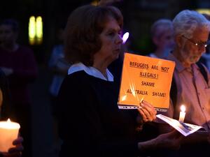 This picture taken on April 30, 2016 shows participants holding placard and candles during a vigil in Sydney for an Iranian refugee who died after setting himself on fire on the Pacific island of Nauru. (AFP/Saeed Khan) This picture taken on April 30, 2016 shows participants holding placard and candles during a vigil in Sydney for an Iranian refugee who died after setting himself on fire on the Pacific island of Nauru. (AFP/Saeed Khan)