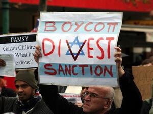 Protesters hold placards in support of the Boycott, Divestment, and Sanctions (BDS) movement. (Wikimedia)