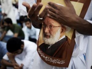 Protesters hold a poster of Sheikh Isa Qassim. (AFP/File)