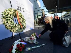A woman places flowers at Brussels' international airport in Zaventem during a memorial ceremony to mark the first anniversary of the twin Brussels attacks on March 22, 2017. (Emmanuel Dunand)