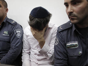Police escort Yosef Haim Ben-David, one of the Jewish suspects of the murder of Muhammed Abu Khdeir, in the Disctrict Court in Jerusalem. (AFP/Ahmad Gharabli)
