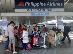 Passengers standing at the Philippine Airlines terminal at Manila International Airport on August 11, 2015. (AFP)