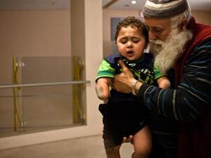 Little Mohammed has lost his arm, legs and sadly, the care of his parents. Thankfully, he has a grandfather looking after him. (AP)