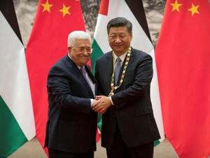 الرئيس الفلسطيني محمود عباس (يسارا) يصافح نظيره الصيني شي جين بينغ في بكين يوم الثلاثاء
