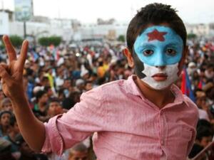 طفل وجهه مطلي بالوان علم اليمن الجنوبي خلال تظاهرة في عدن
