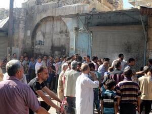 رجال ينتظرون الحصول على معونات غذائية في حلب
