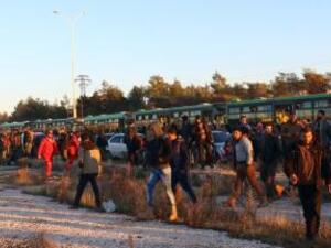 اناس تم إجلاؤهم من مناطق شرق حلب التي تسيطر عليها المعارضة ينزلون من حافلات عند وصولهم لحي الراشدين في سوريا يوم الخميس
