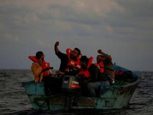 مهاجرون ليبيون على قارب خشبي يحتفلون ويتخذون صورة سيلفي أثناء إنقاذهم
