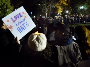 متظاهرة تحمل لافتة مكتوب عليها "الحب يغلب الكراهية" خلال وقفة بالشموع احتجاجا على انتخاب الرئيس الأمريكي المنتخب دونالد ترامب بالقرب من البيت الأبيض في واشنطن
