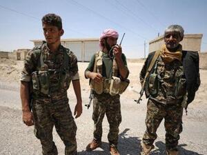 مقاتلون من قوات سوريا الديمقراطية في الرقة يوم الأحد

