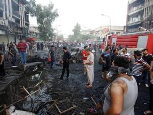 أشخاص في موقع تفجير انتحاري في حي الكرادة ببغداد
