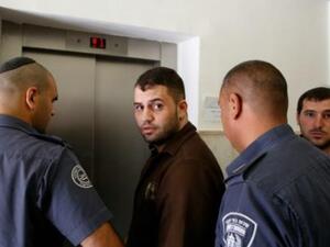 الفلسطيني بلال ابو غانم لدى مغادرة المحكمة بين جنود اسرائيليين في القدس
