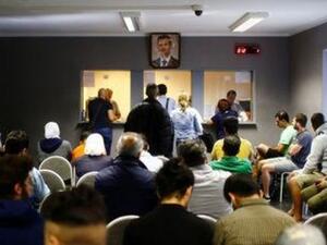 لاجئون سوريون بالسفارة السورية في برلين
