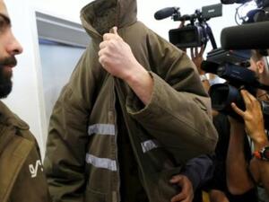 الموظف القنصلي الفرنسي رومان فرانك يخفي وجهه لدى مثوله امام محكمة بئر السبع
