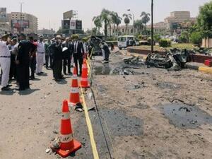 مسؤولو أمن وحققون يتفقدون موقع انفجار سيارة بالقاهرة يوم الاثنين
