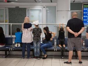 عائلات تنتظر وصول أناس قادمين من الرياض عاصمة السعودية إلى مطار بيرسون الدولي في تورنتو بمقاطعة أونتاريو بكندا يوم الجمعة

