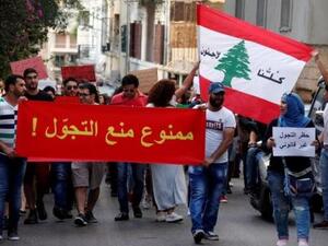أشخاص يشاركون في مظاهرة ضد الطائفية وتدعو لإلغاء حظر التجول المفروض على اللاجئين السوريين في بيروت
