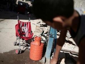 صبي يملأ وعاء بالماء في إحدى ضواحي دمشق
