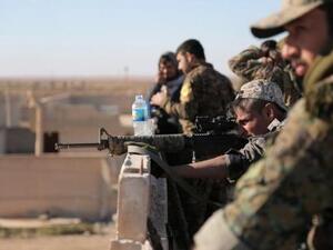 مقاتلون من قوات سوريا الديمقراطية في قرية شمال مدينة الرقة بسوريا
