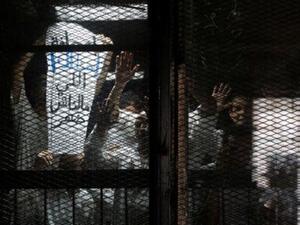 المصور المصري محمود ابو زيد (يمينا) مع صحفيين آخرين اثناء احدى جلسات محاكمتهم

