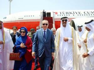 إردوغان (في المنتصف) وإلى يمينه أمير قطر لدى وصوله إلى مطار الدوحة يوم الاثنين
