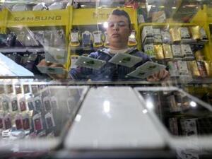 فلسطيني يعرض شرائح للهاتف المحمول تابعة لشركة جوال الفلسطينية في متجر بمدينة غزة
