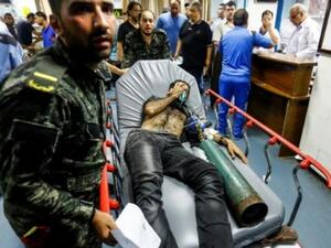 عناصر في حركة حماس ينقلون فلسطينيا اصيب في الغارات الاسرائيلية لتلقي عناية طبية في مستشفى الشفاء في غزة
