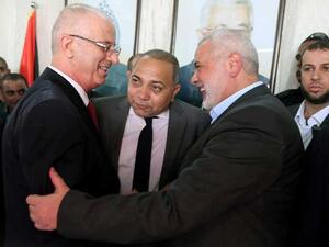 رئيس المكتب السياسي لحركة المقاومة الإسلامية حماس، اسماعيل هنية (يمين) يصافح رئيس حكومة الوفاق الفلسطينية رامي الحمدالله