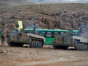 مقاتلون تابعون لحزب الله يرافقون حافلات في جرود عرسال في لبنان
