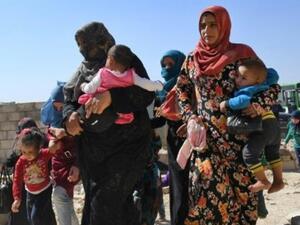 سوريات مع اطفالهن عند وصولهم الى المنطقة الخاضعة لسيطرة النظام في محافظة إدلب
