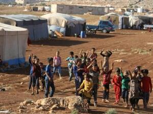 أطفال يتجمعون في مخيم للنازحين من جنوب ادلب وشمال حماة في كفر دريان قرب الحدود السورية-التركية
