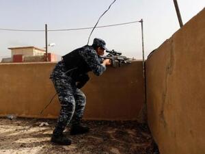 شرطي عراقي يصوب بندقيته على مواقع لمقاتلي تنظيم الدولة الإسلامية خلال اشتباكات في غرب الموصل
