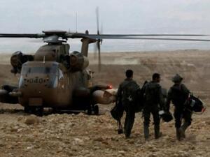 جنود اسرائيليون الى جانب مروحية يشاركون في اعمال البحث عن مفقودين اثر فيضانات في منطقة البحر الميت ادت الى مقتل عشرة تلامذة
