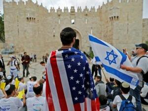 اسرائيلي يلف نفسه بعلم أميركي في المدينة القديمة في القدس

