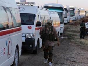 مقاتلون إسلاميون من هيئة تحرير الشام بجوار سيارات إسعاف قرب بلدتي الفوعة وكفريا بإدلب
