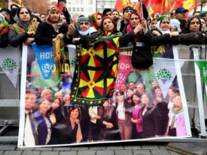 متظاهرون اكراد في كولونيا خلف صورة للسياسيين الاكراد الموقوفين

