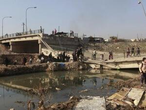 مشردون يعبرون جسرا في ضاحية المثنى بالموصل
