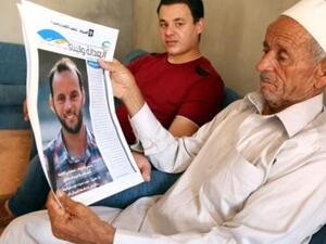 عبد الله حميدة يحمل صورة ابنه عبد القادر الذي سقط اثناء قتاله ضمن قوات حكومة الوفاق الوطني الليبية لاستعادة سرت
