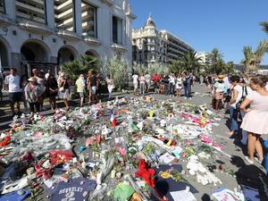 People gather near flowers placed at a makeshift memorial near the Promenade des Anglais in Nice on July 17, 2016, in tribute to the victims of the Bastille Day attack that left 84 dead. (AFP/Valery Hache People gather near flowers placed at a makeshift memorial near the Promenade des Anglais in Nice on July 17, 2016, in tribute to the victims of the Bastille Day attack that left 84 dead. (AFP/Valery Hache