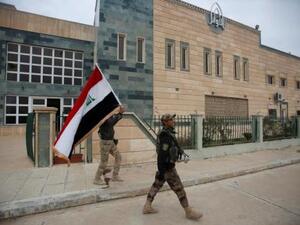 جندي عراقي يحمل علم بلاده في الموصل
