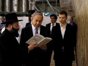 رئيس الوزراء الإسرائيلي بنيامين نتنياهو (وسط الصورة) وابنه يائير (يمينا) عند الحائط الغربي في البلدة القديمة بالقدس

