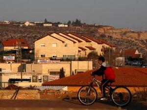 صبي يستقل دراجة ويمر عبر منازل في مستوطنة عوفرا الاسرائيلية في الضفة الغربية 
