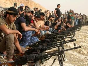 مقاتلون من المعارضة السورية خلال عرض لاسلحتهم قرب مدينة درعا 
