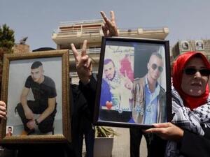 فلسطينيون يرفعون صور أقاربهم المضربين عن الطعام في السجون الإسرائيلي في احتجاج للتضامن معهم في القدس الشرقية
