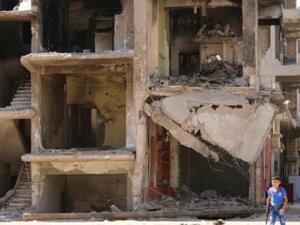 ارشيف/ طفل يمر امام مبنى مدمر في القامشلي