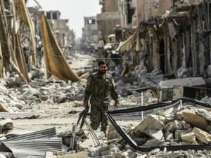 عنصر من قوات سوريا الديموقراطية يجول بين أنقاض الحي القديم في الرقة

